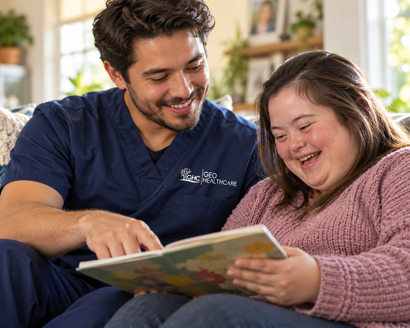 A Geo HealthCare support staff member reading a book together with an adult he supports, both smiling